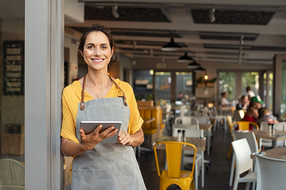 Small business owner at entrance of business